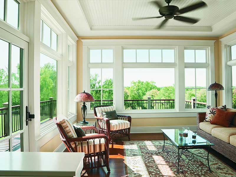 The interior of a home with beautiful windows and a wooden chair