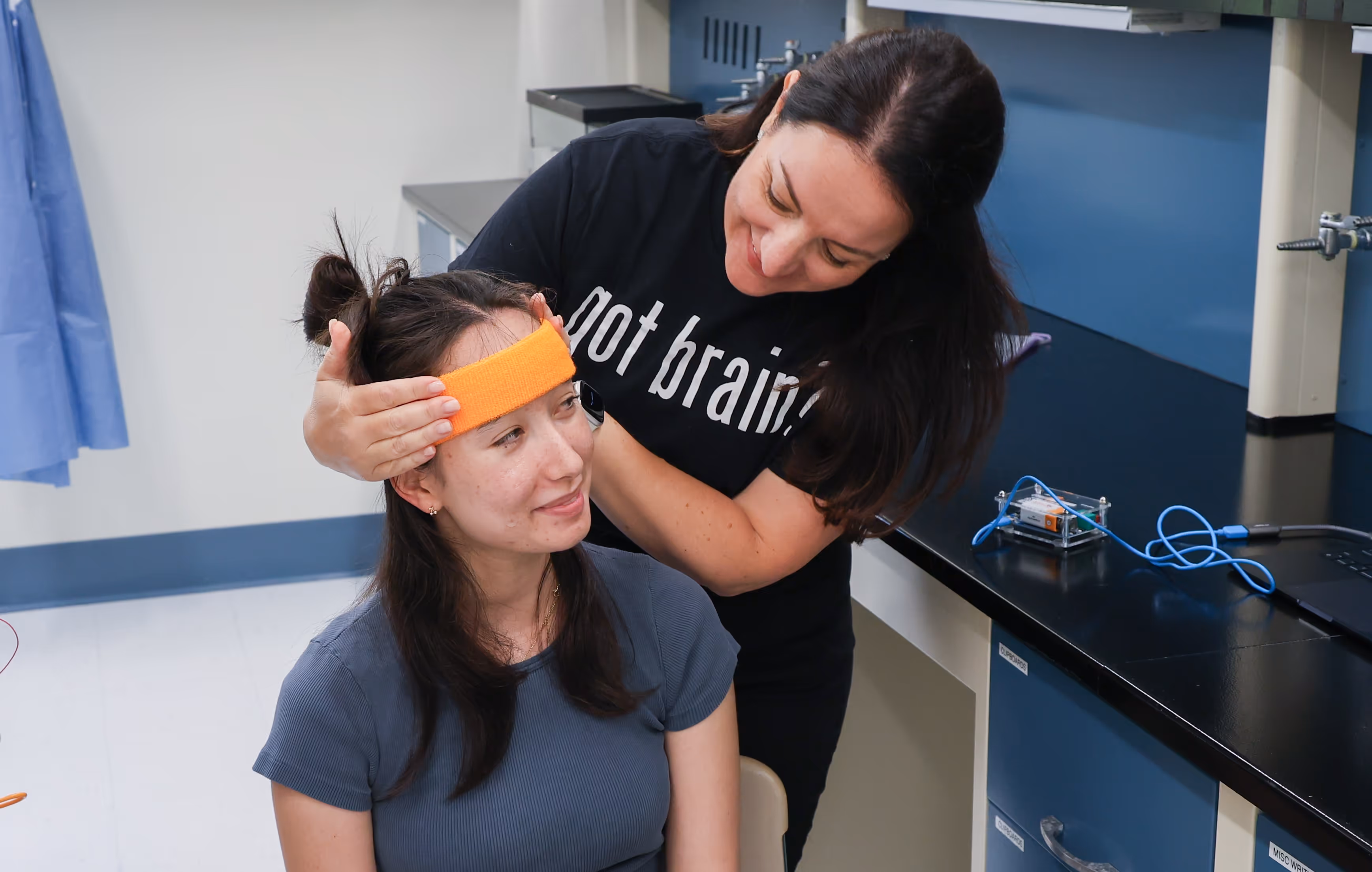 Student receiving hands-on brain science demonstration with headband during neuroscience outreach program