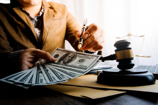 lawyer holding settlement money and pen