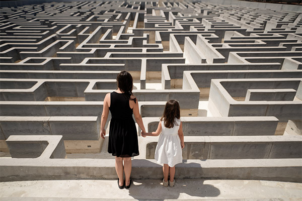 QSF Secure a child's future - woman and child looking at vast intricate maze