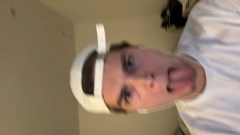 Person with white hat sticking out tongue in playful selfie