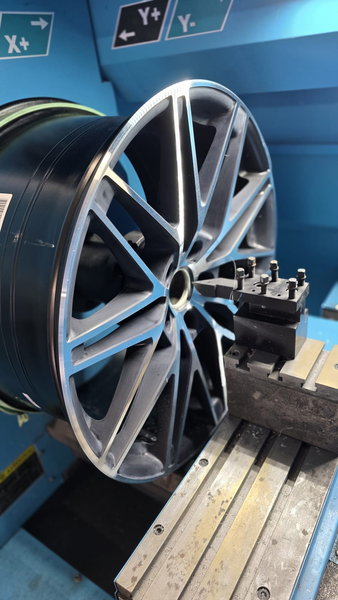 Roue en alliage montée sur une machine pour usinage ou équilibrage dans un atelier mécanique.