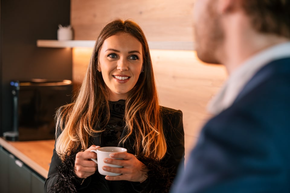Lisa Daniels, Talent Manager bij Jorissen & De Jonck, aan het praten met een collega terwijl ze een tas koffie vasthoudt.