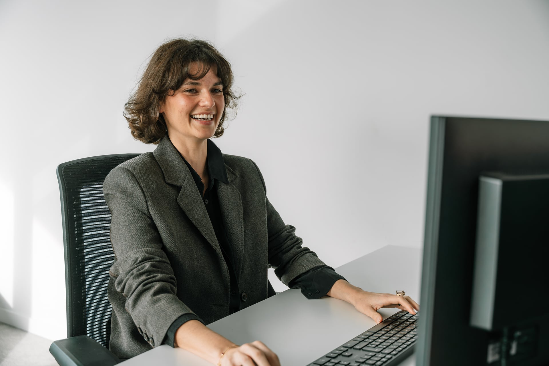 Manon achter haar computer aan een bureau op kantoor van Jorissen & De Jonck.