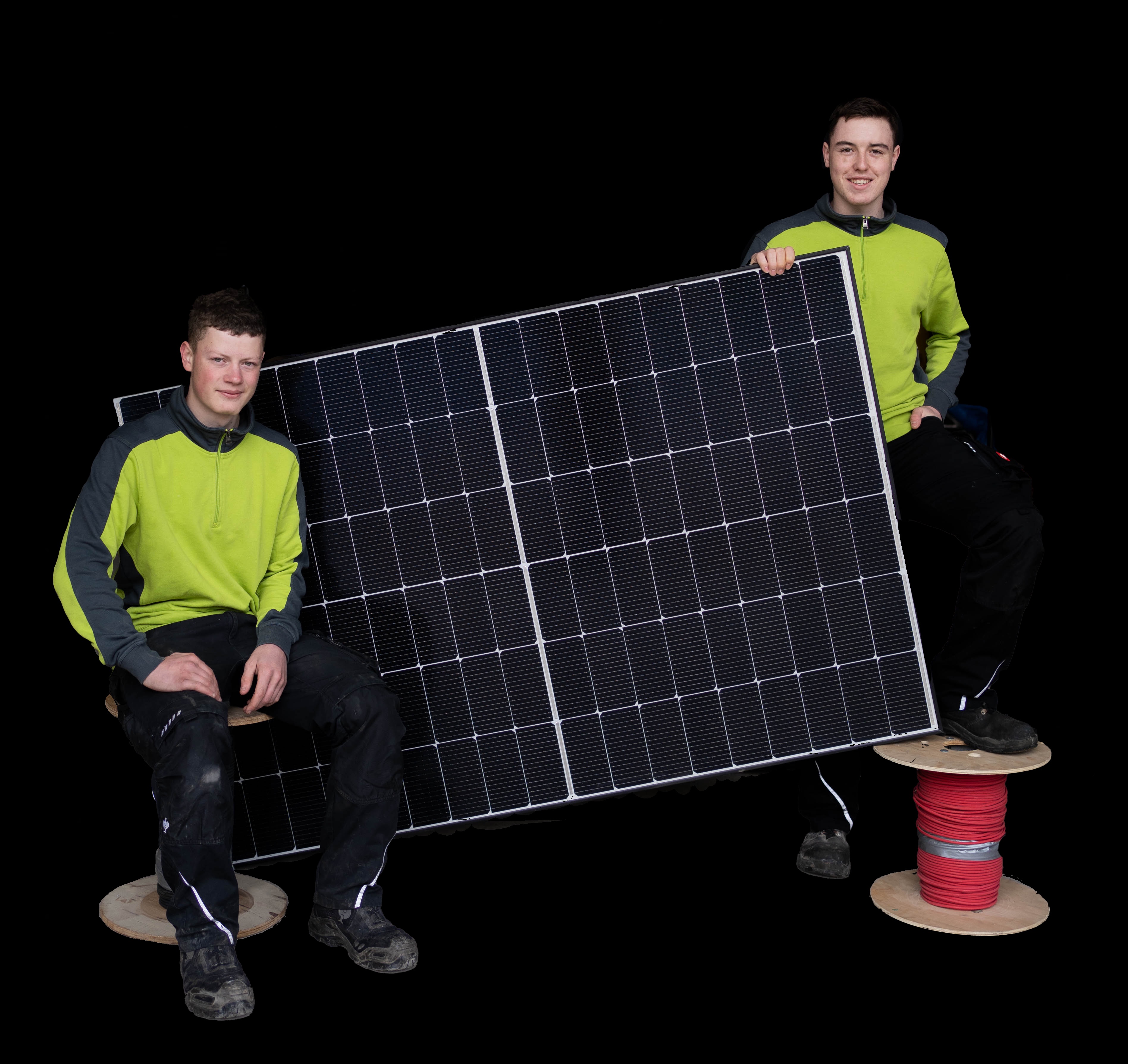 Zwei Techniker mit Solarmodul und roter Kabelrolle auf schwarzem Hintergrund