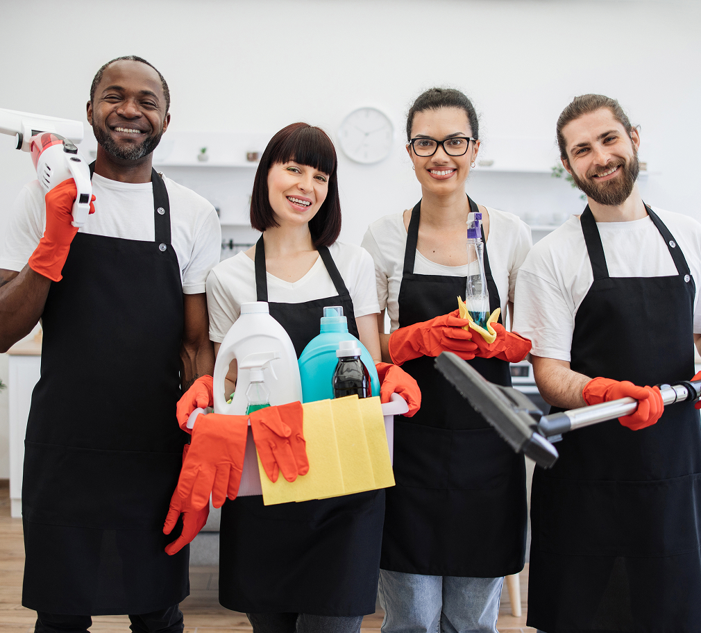 Group of professional cleaners posing with cleaning supplies