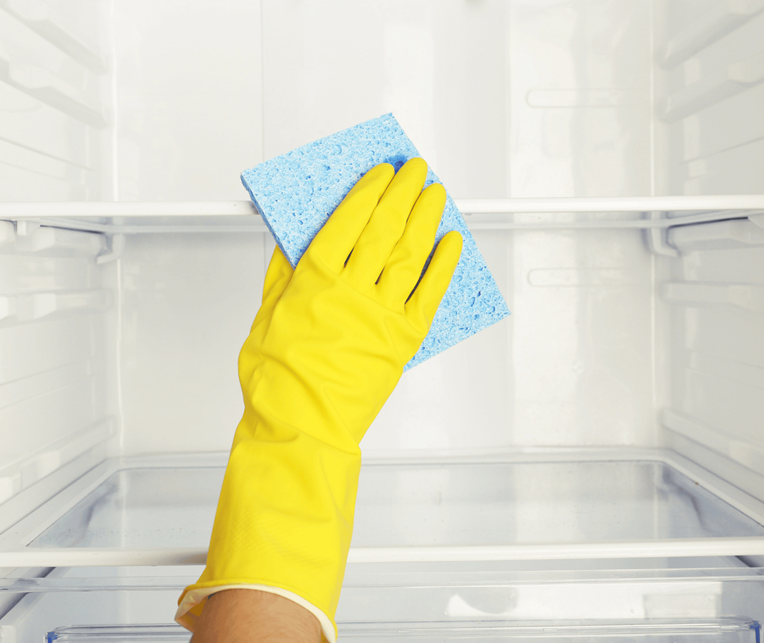 Hand in yellow glove wiping glass surface