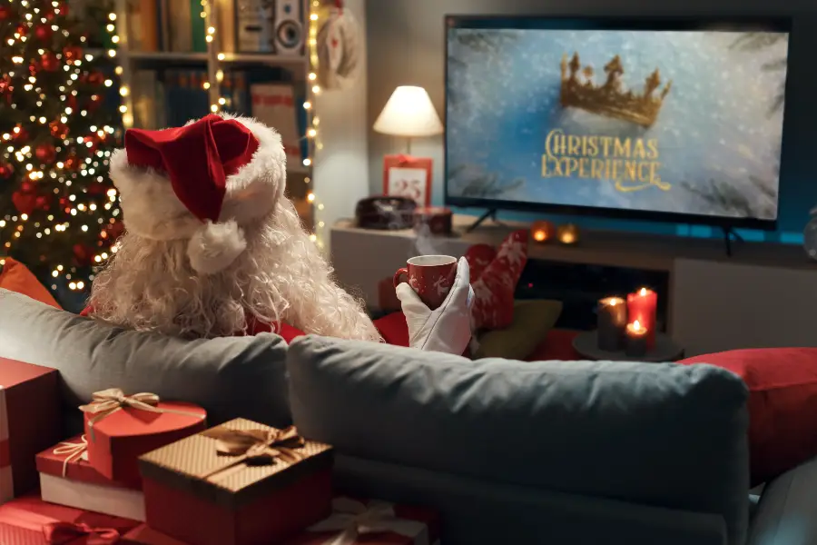 Weihnachtsmann genießt das "Christmas Experience"-Live-Event auf YouTube im festlich dekorierten Raum