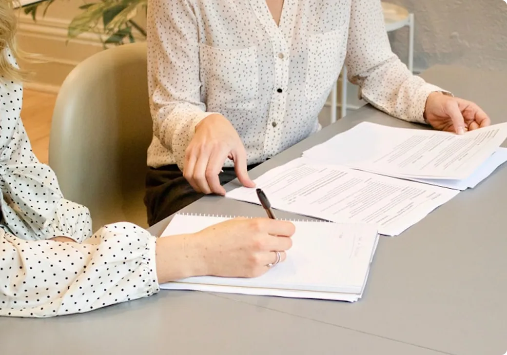 Two people reviewing documents together at table.