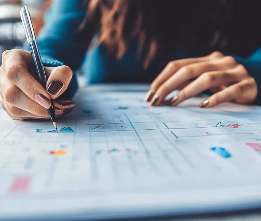 Hände schreiben Notizen auf Papier im Büro