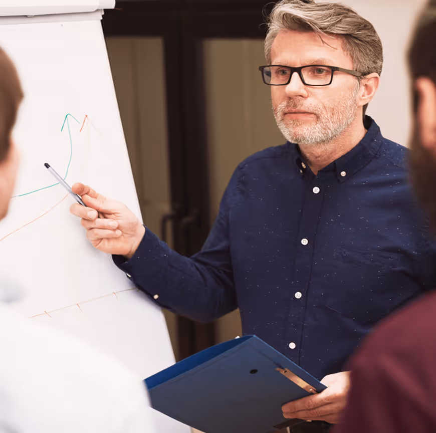 Mann präsentiert mit Tablet vor Kollegengruppe