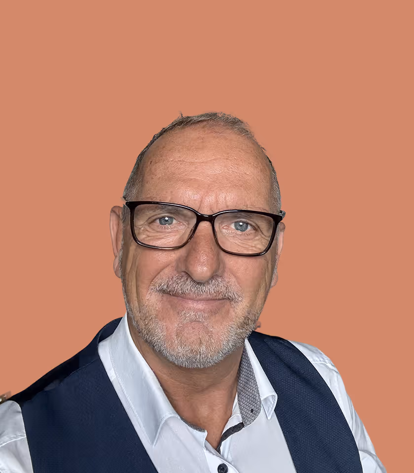 Porträt eines Mannes mit Brille vor braunem Hintergrund