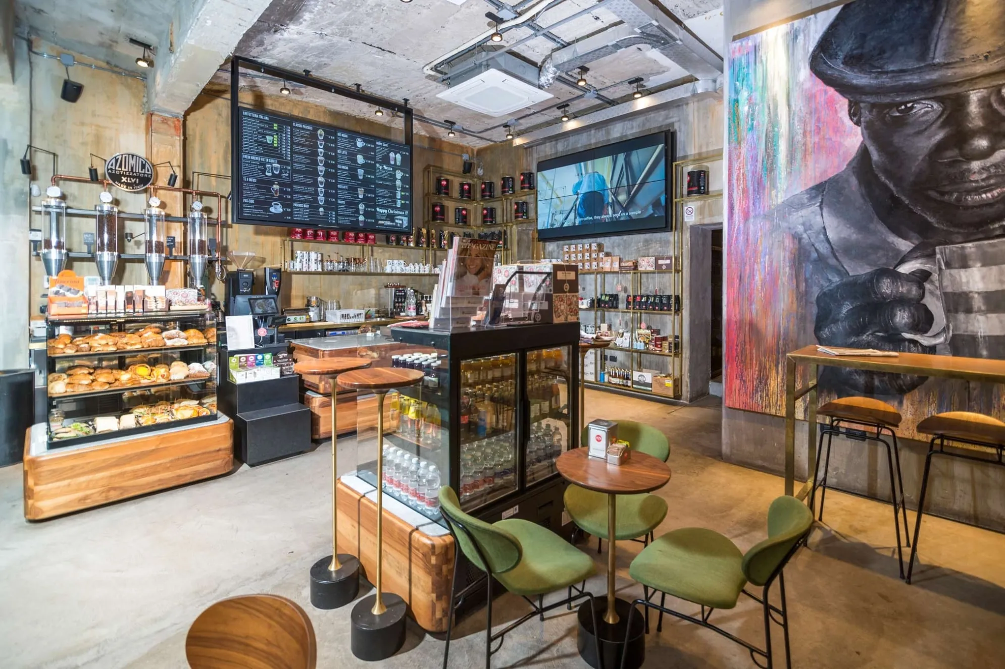 Interno di un ristorante moderno con sedie colorate, tavoli con tovagliette astratte e pareti decorate con murales.