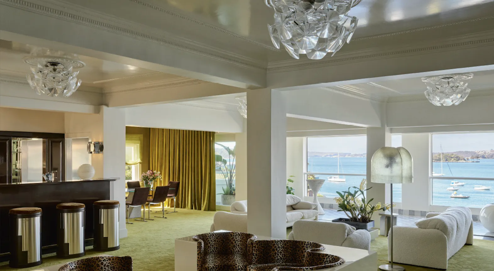 Interno di una sala conferenze moderna con pareti grigie, sedie da ufficio nere e illuminazione soffusa.