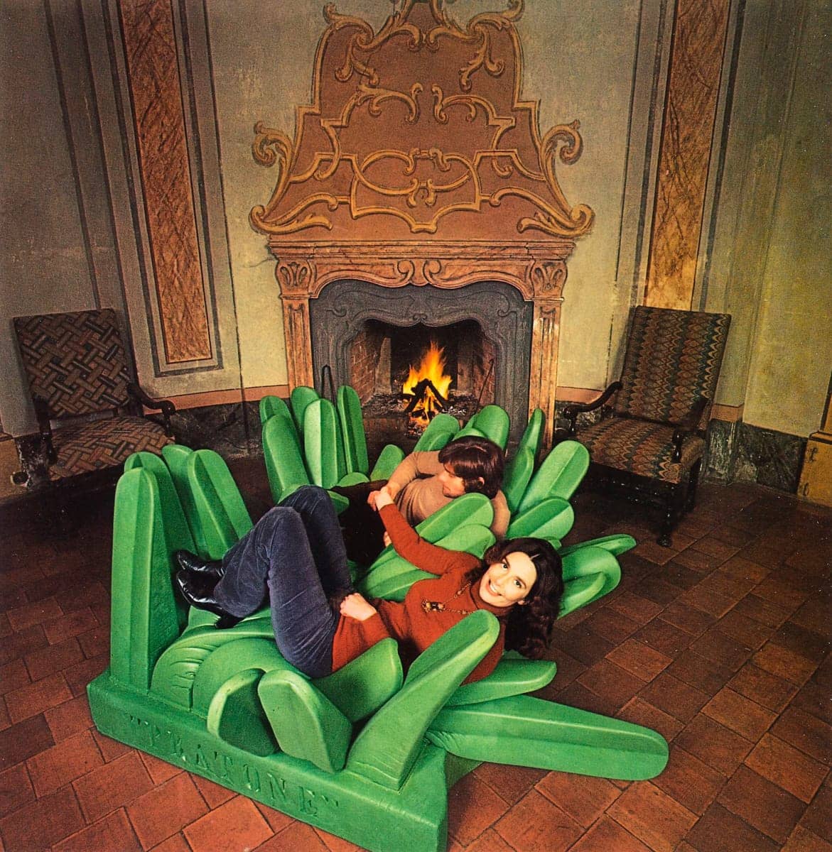 Tavolo rettangolare nero con quattro sedie in vimini e lampada ad arco con base rettangolare bianca, vista dall'alto.