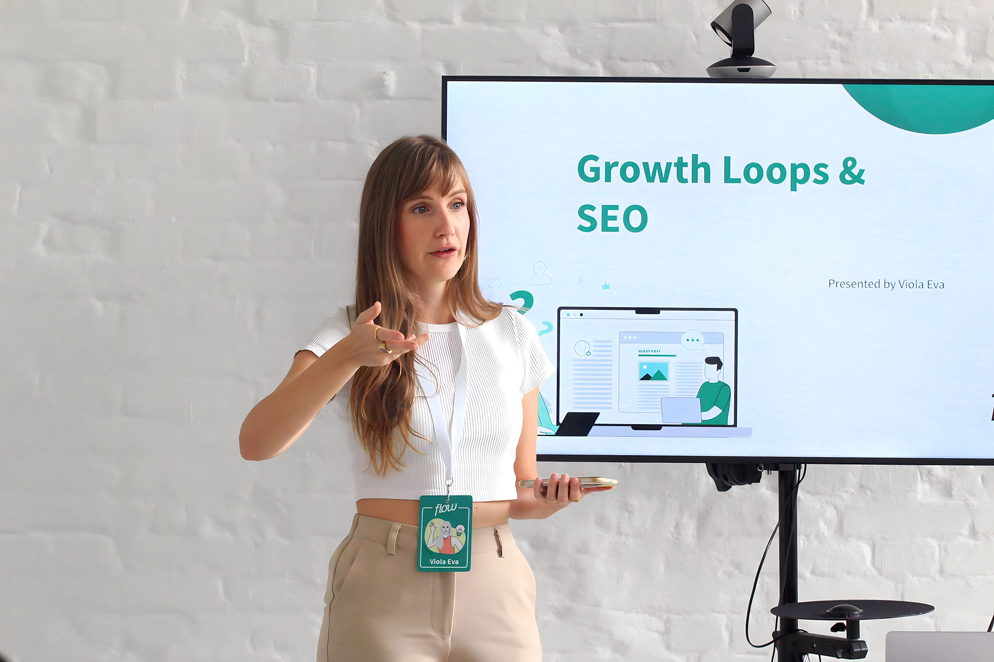 Viola presenting a corporate training on 'Growth Loops & SEO' with a large screen behind her.