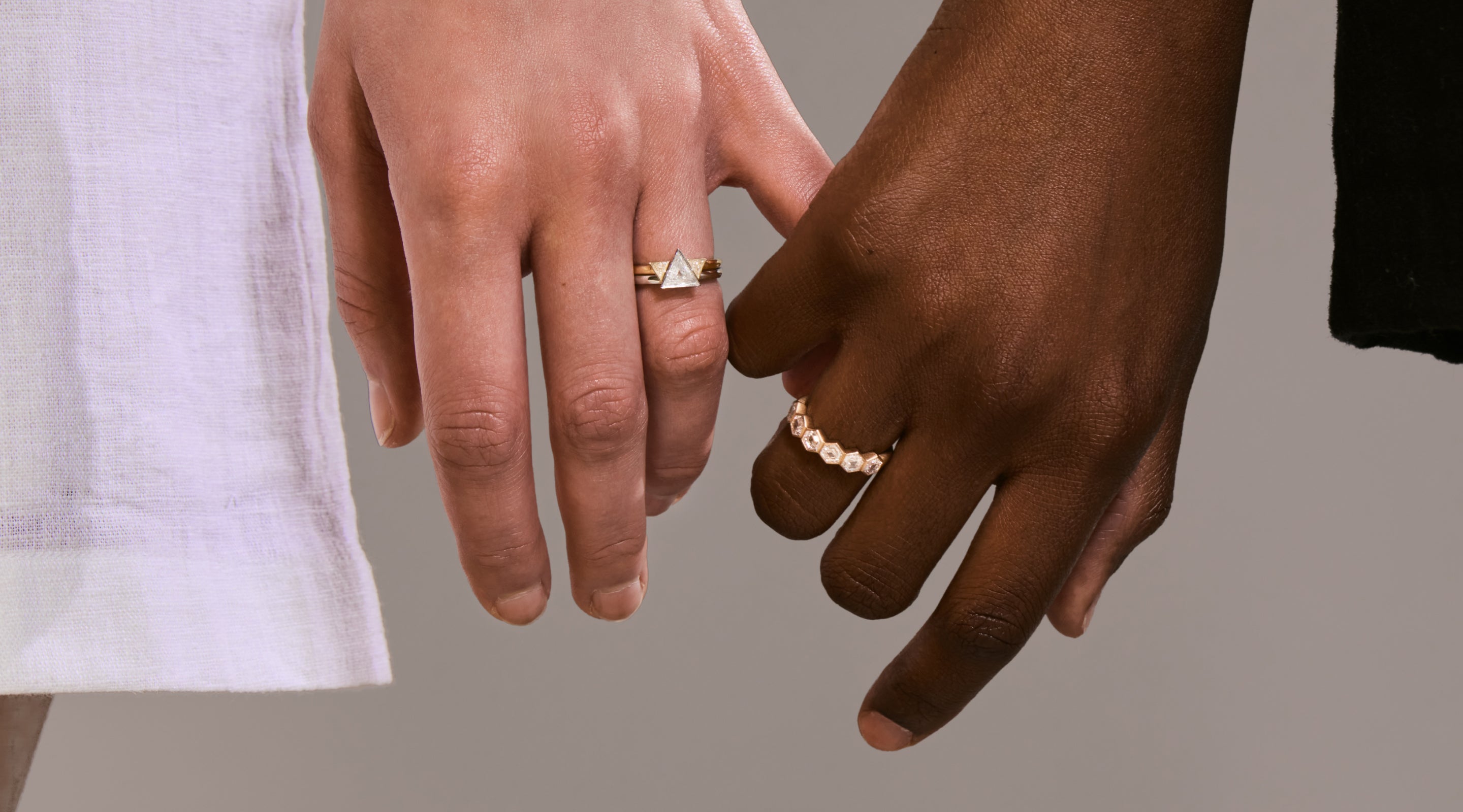 Blonde woman with slicked-back hair wearing a black strapless top and a choker necklace with a large light blue gemstone.