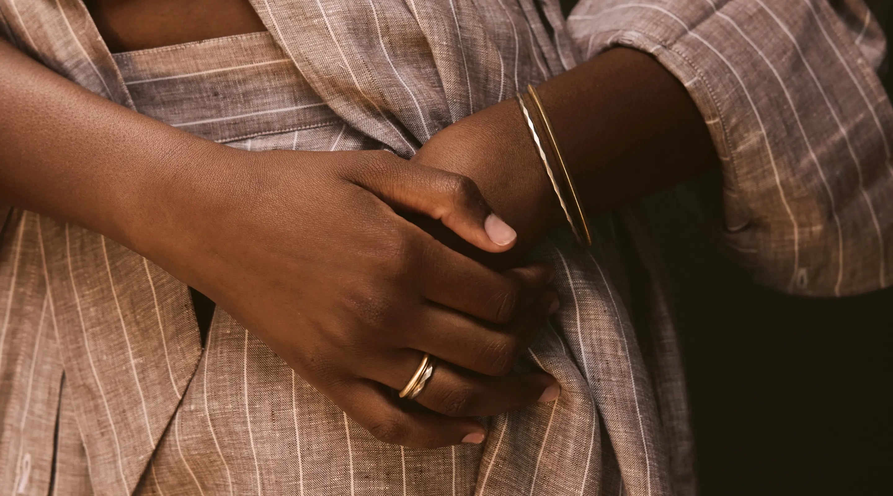 Blonde woman with slicked-back hair wearing a black strapless top and a choker necklace with a large light blue gemstone.
