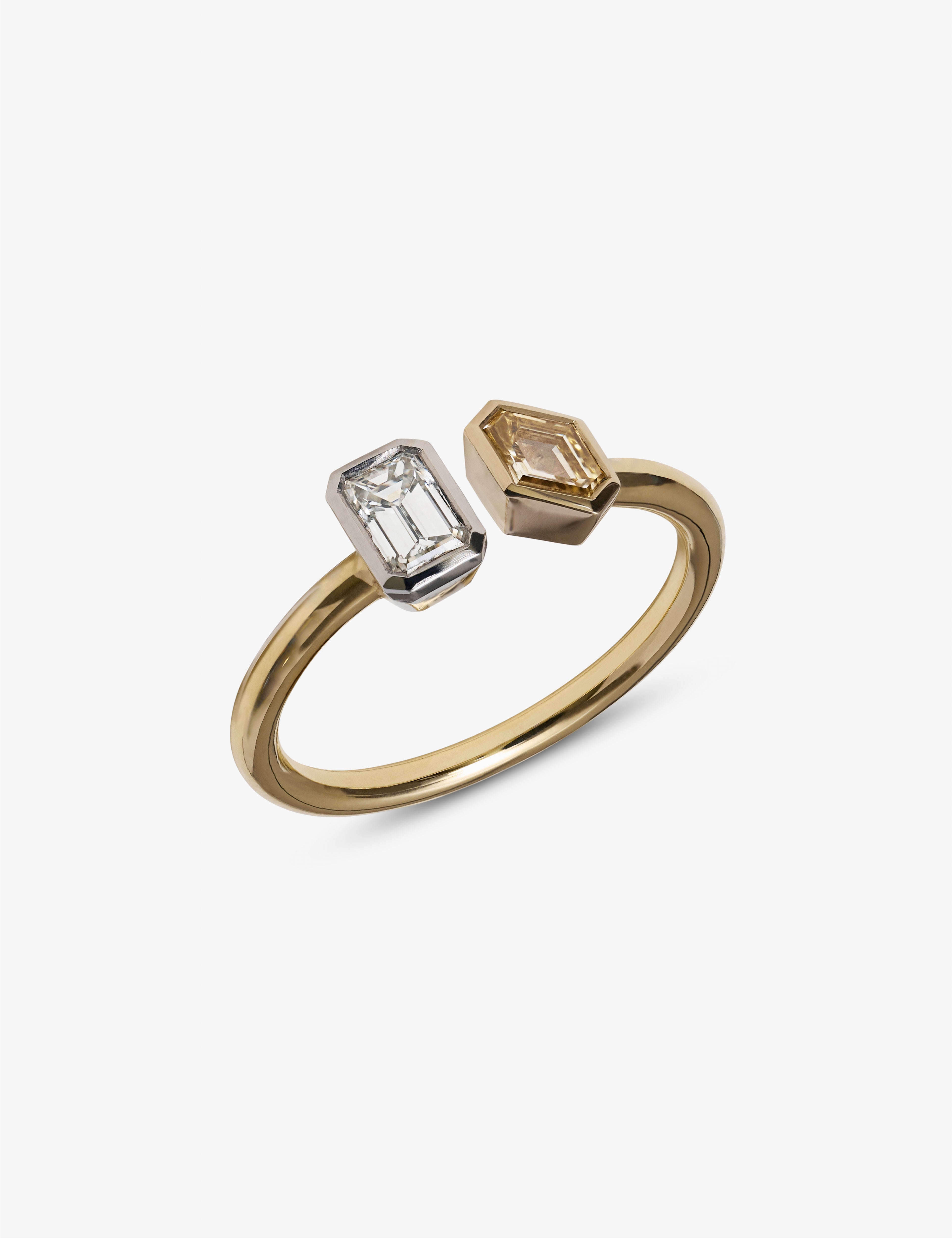 Detailed view of yellow gold toi et moi ring with opposing white and champagne emerald-cut diamonds.