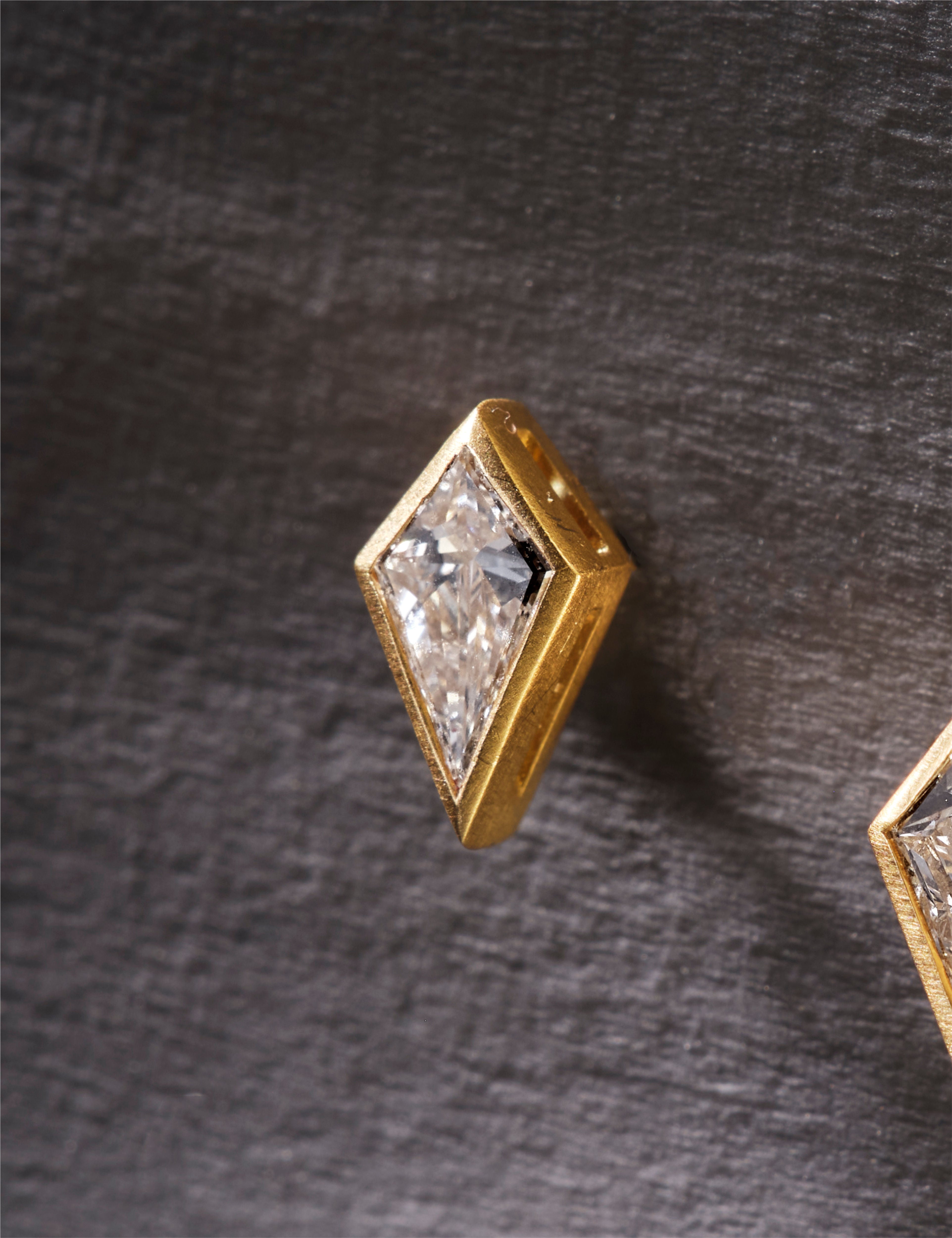 Gold stud earrings with clear gemstones on a white background.