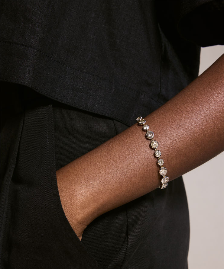 Person wearing a bracelet on a plain background.