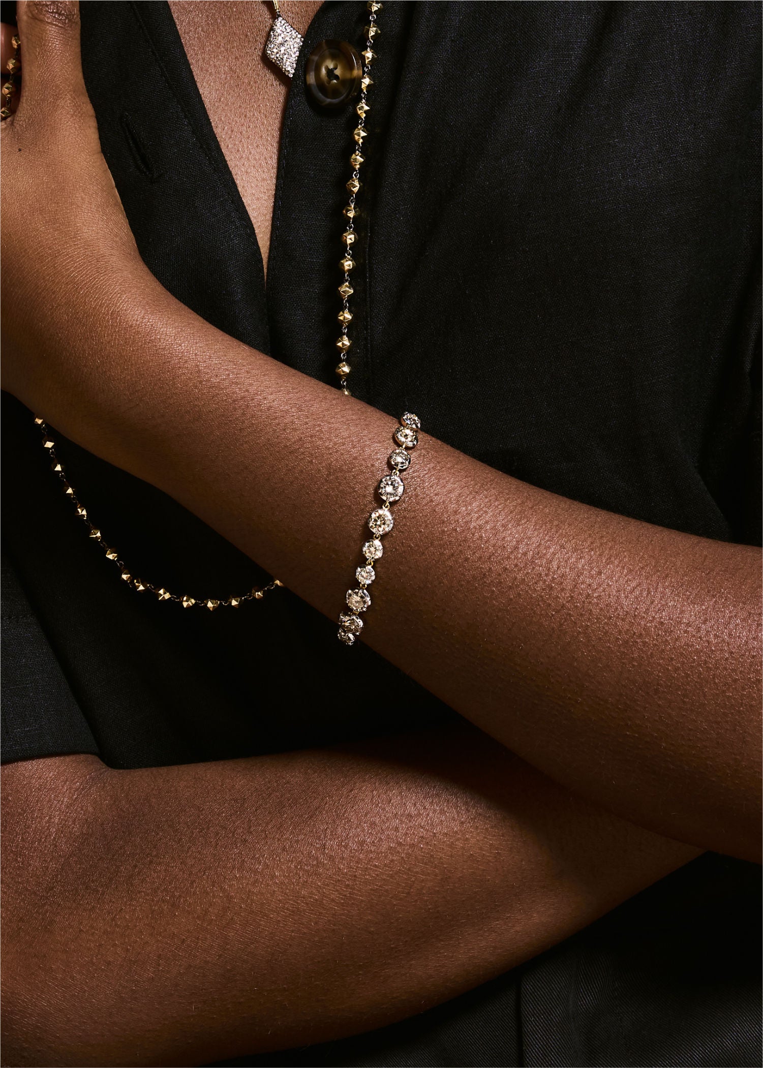 Person wearing a bracelet on a plain background.