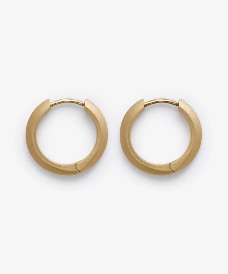 Gold stain hoop earrings on a white background.