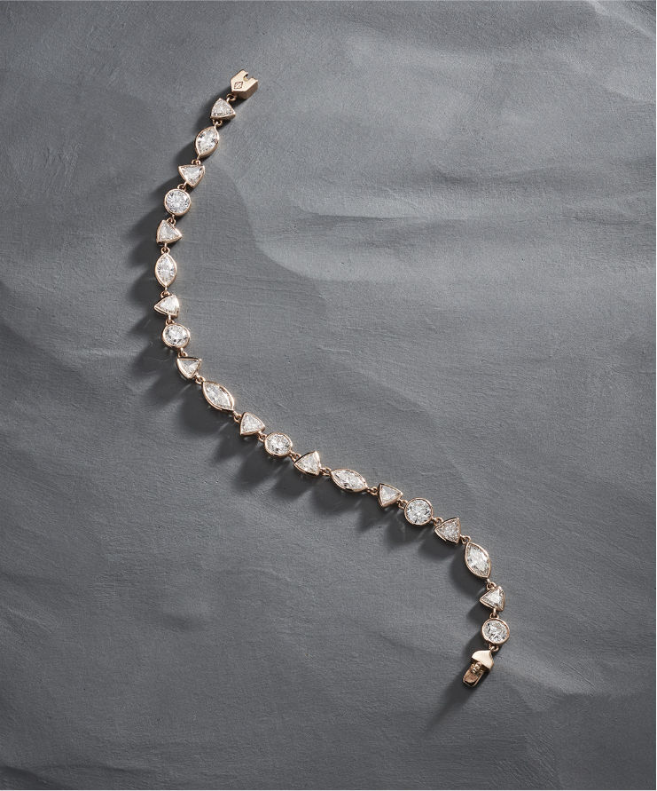 Close-up of rose gold diamond tennis bracelet clasp with round and marquise stones.