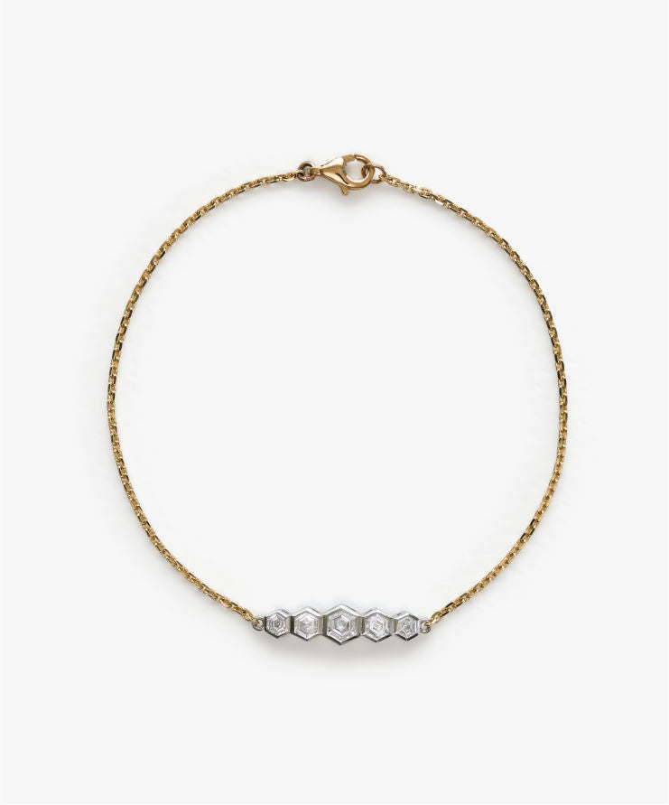 Yellow gold bracelet with five hexagonal diamond settings on white background.