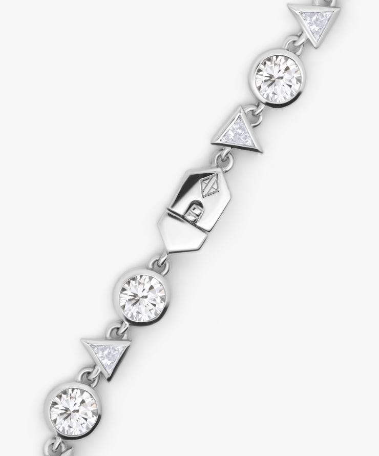Silver bracelet with diamond-like stones on a white background.