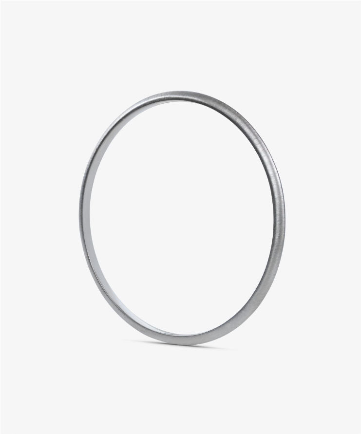 White gold bracelet on a textured gray surface.