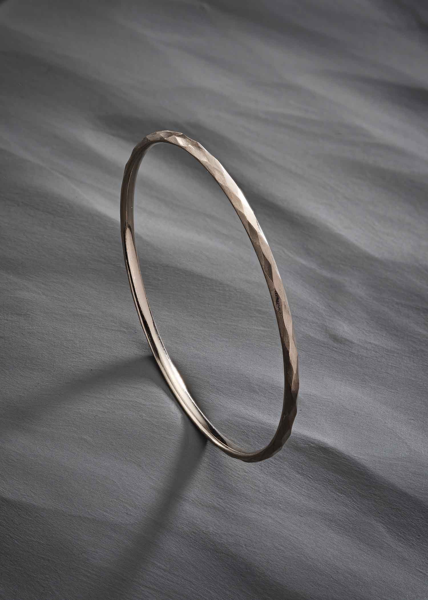 Close-up of a person wearing a brown garment with a belt and cuff details.