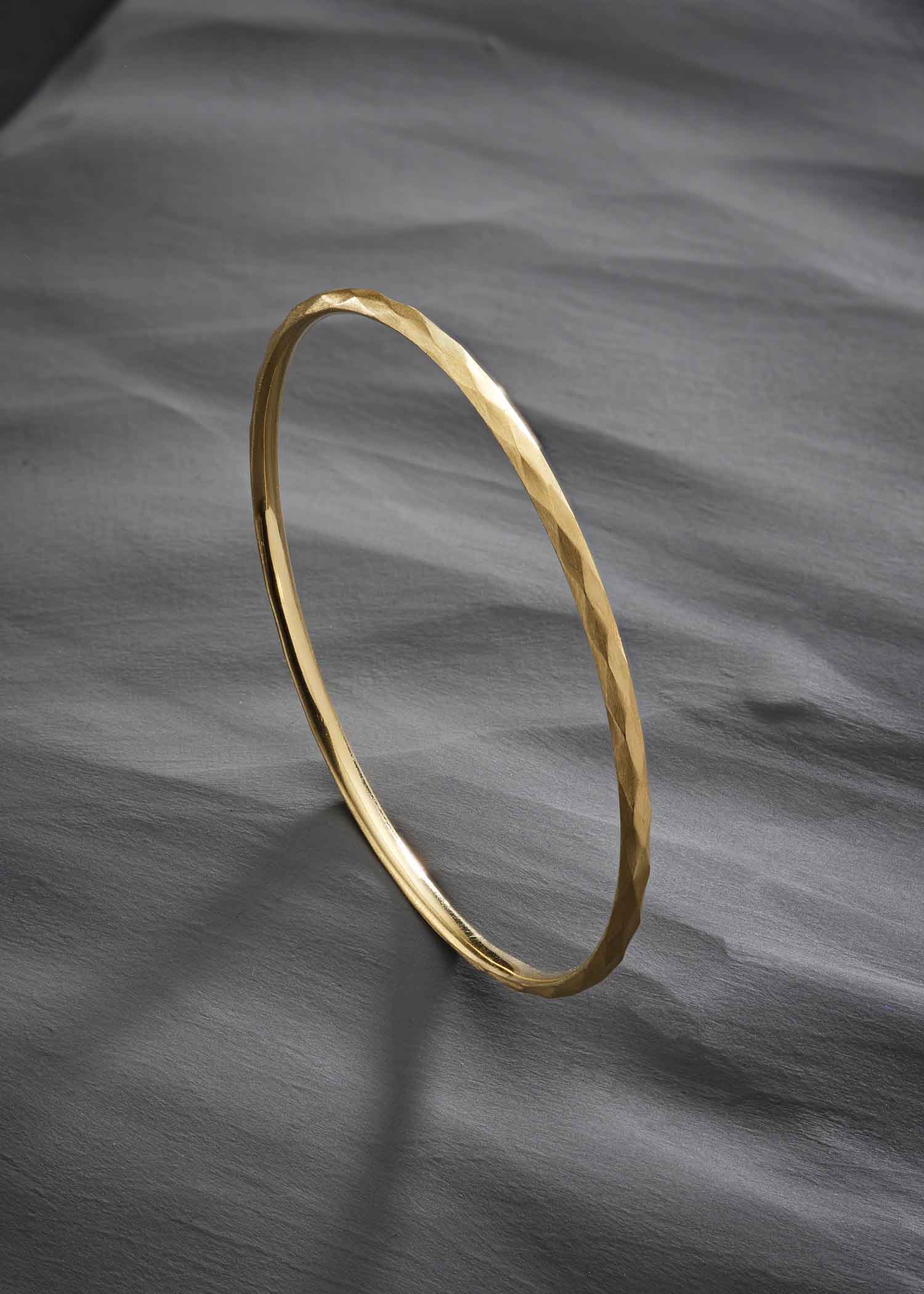 Close-up of a person wearing a brown garment with a belt and cuff details.