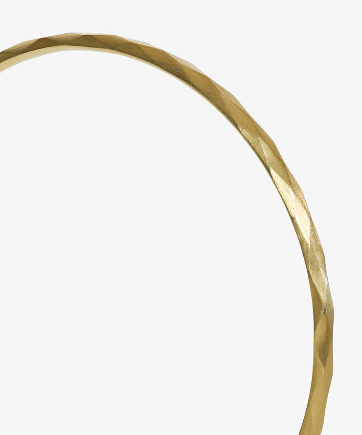 Close-up of a person wearing a brown garment with a belt and cuff details.