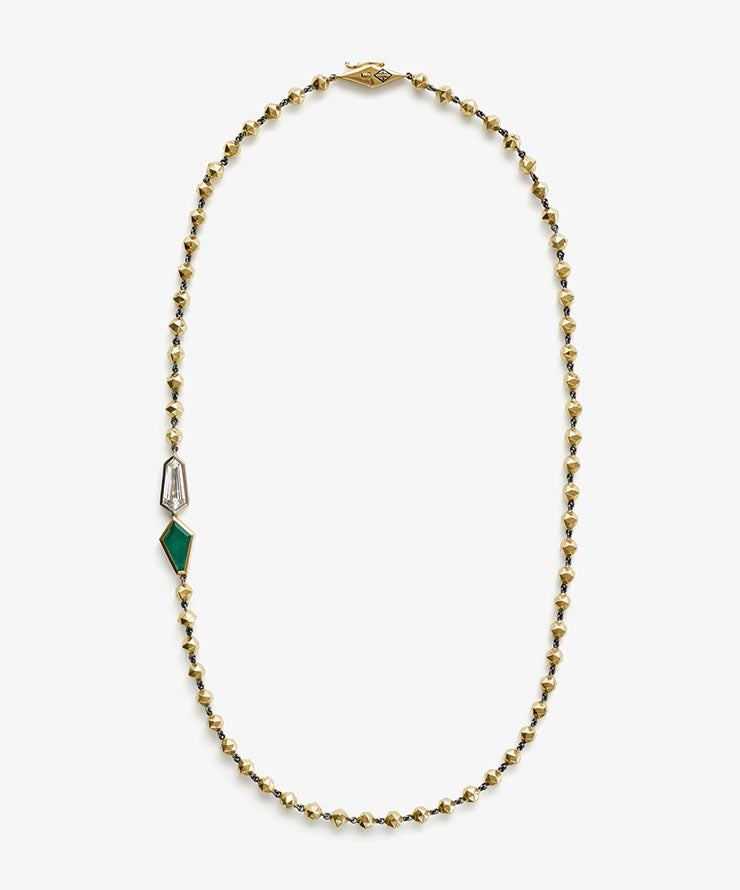 Gold bead necklace featuring a geometric emerald and diamond pendant detail, displayed on a white background.