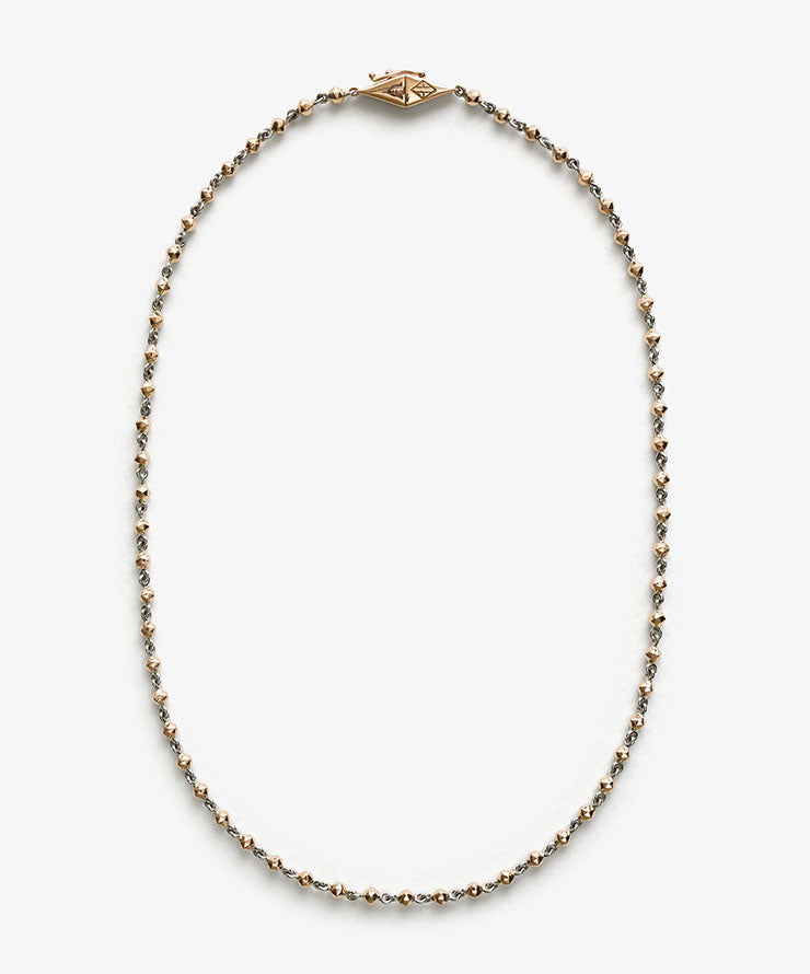 Necklace with gold and silver beads on a white background.