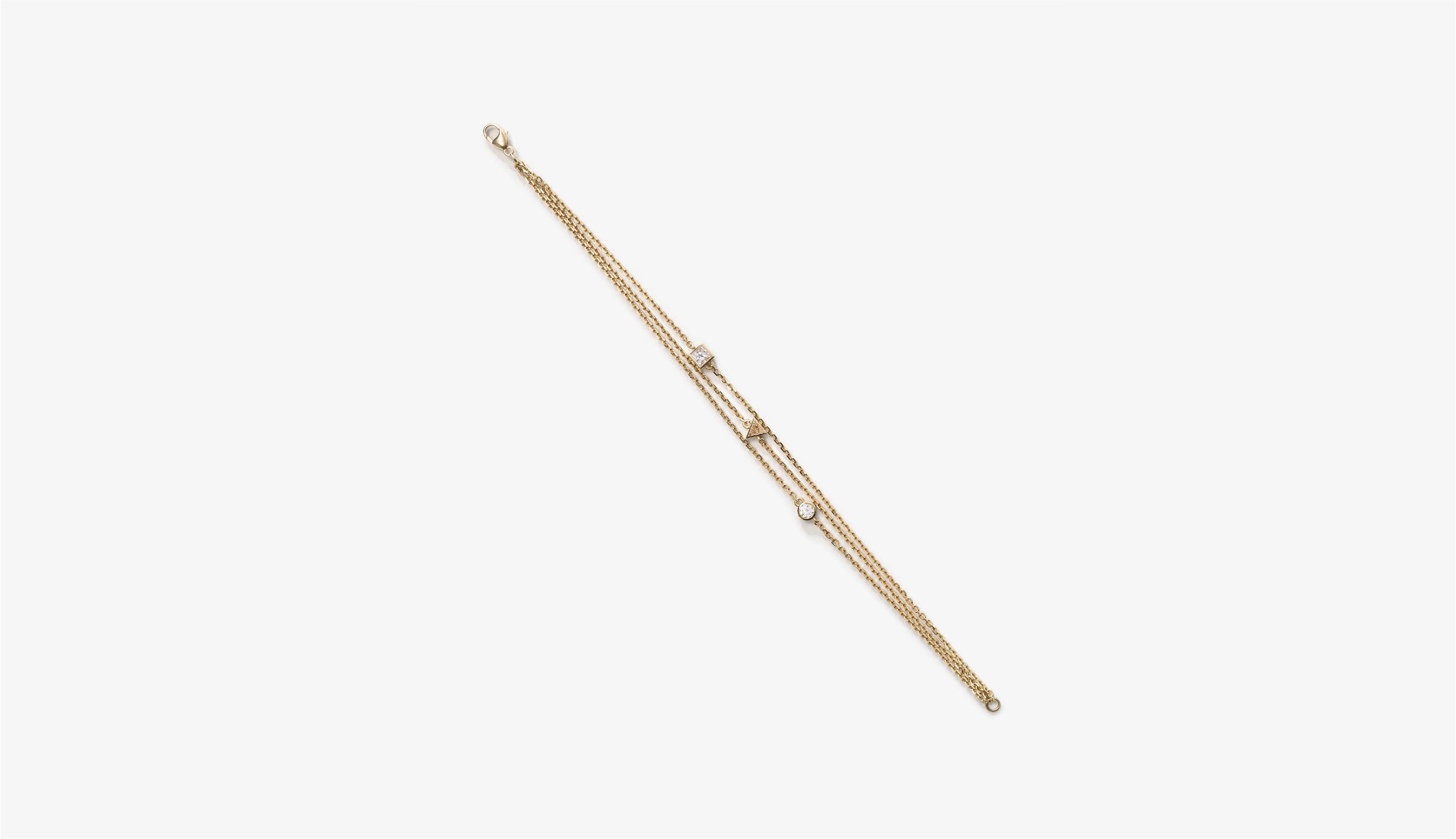 Blonde woman with slicked-back hair wearing a black strapless top and a choker necklace with a large light blue gemstone.