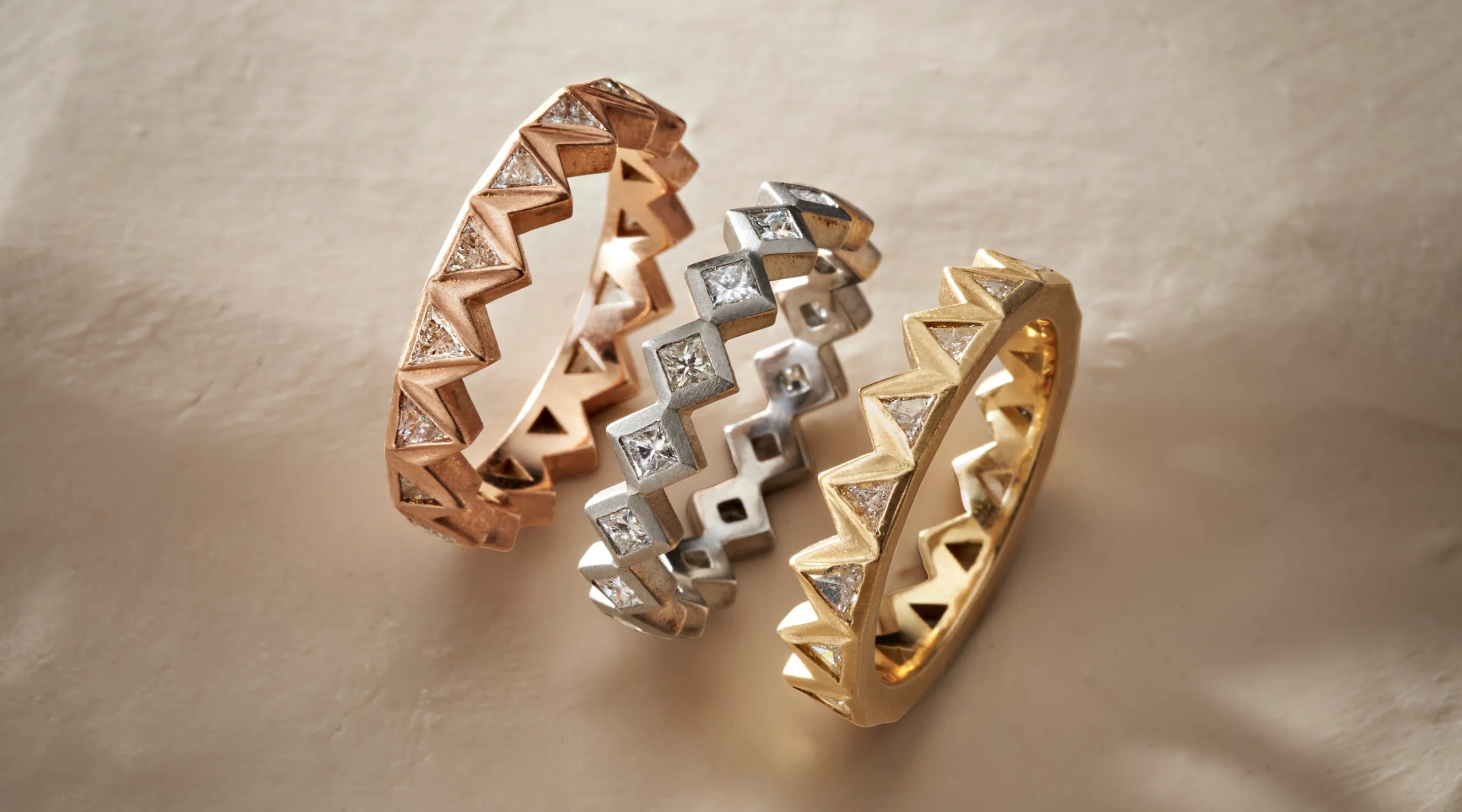 Blonde woman with slicked-back hair wearing a black strapless top and a choker necklace with a large light blue gemstone.