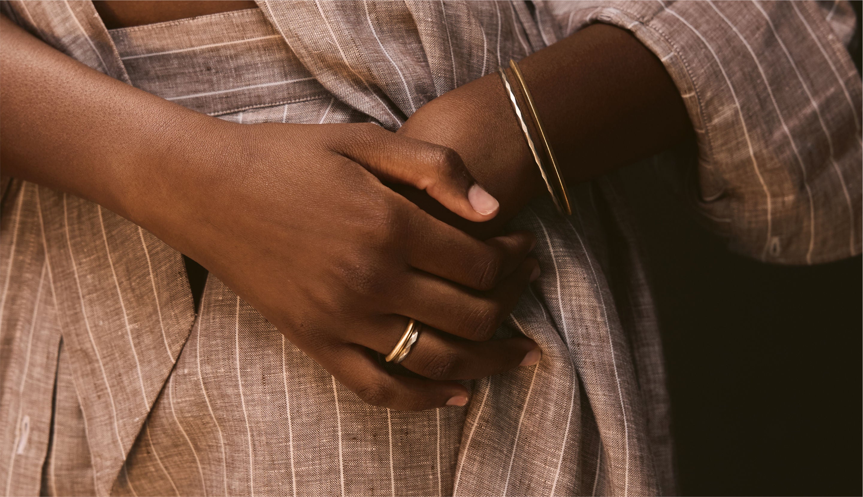 Blonde woman with slicked-back hair wearing a black strapless top and a choker necklace with a large light blue gemstone.