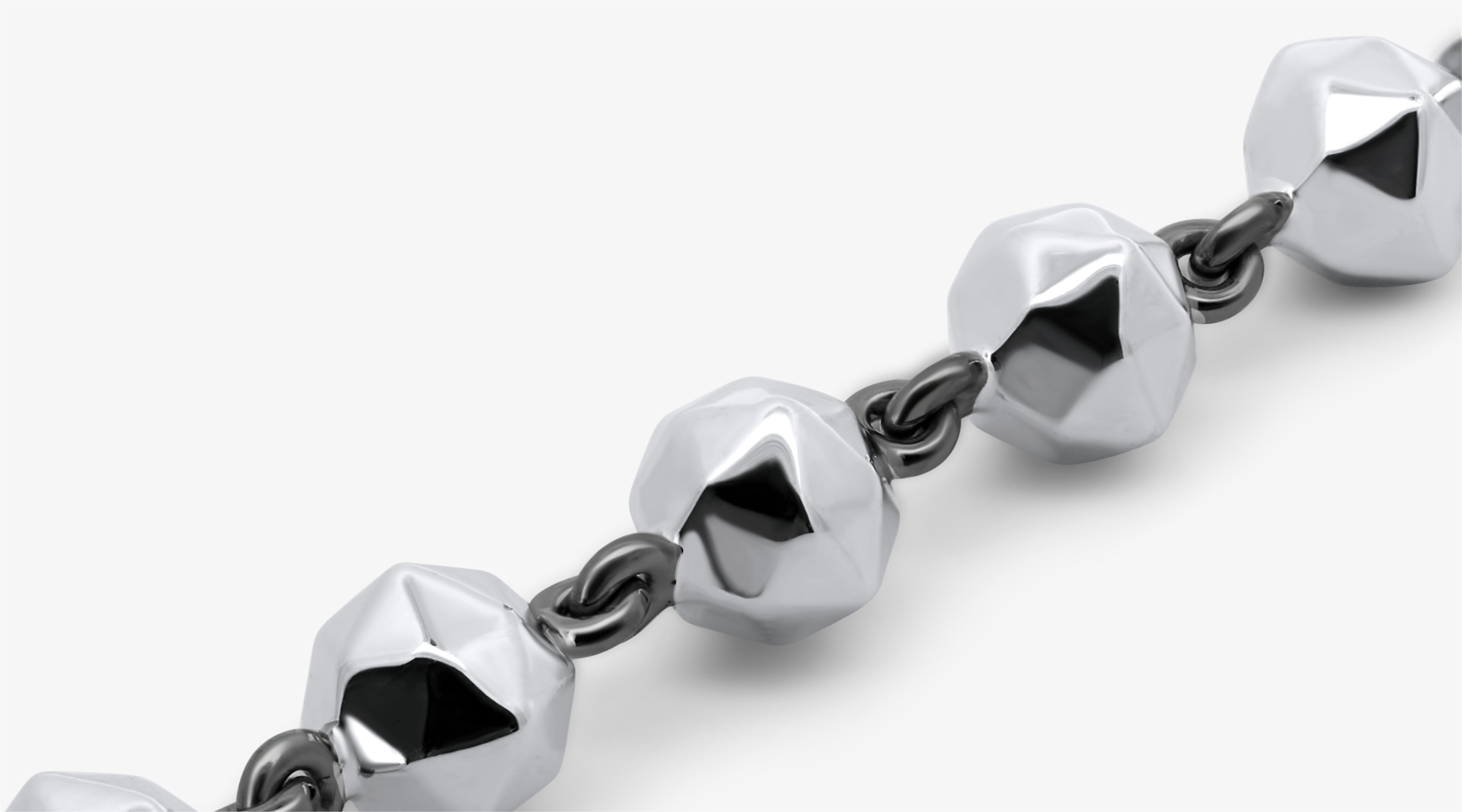 Blonde woman with slicked-back hair wearing a black strapless top and a choker necklace with a large light blue gemstone.