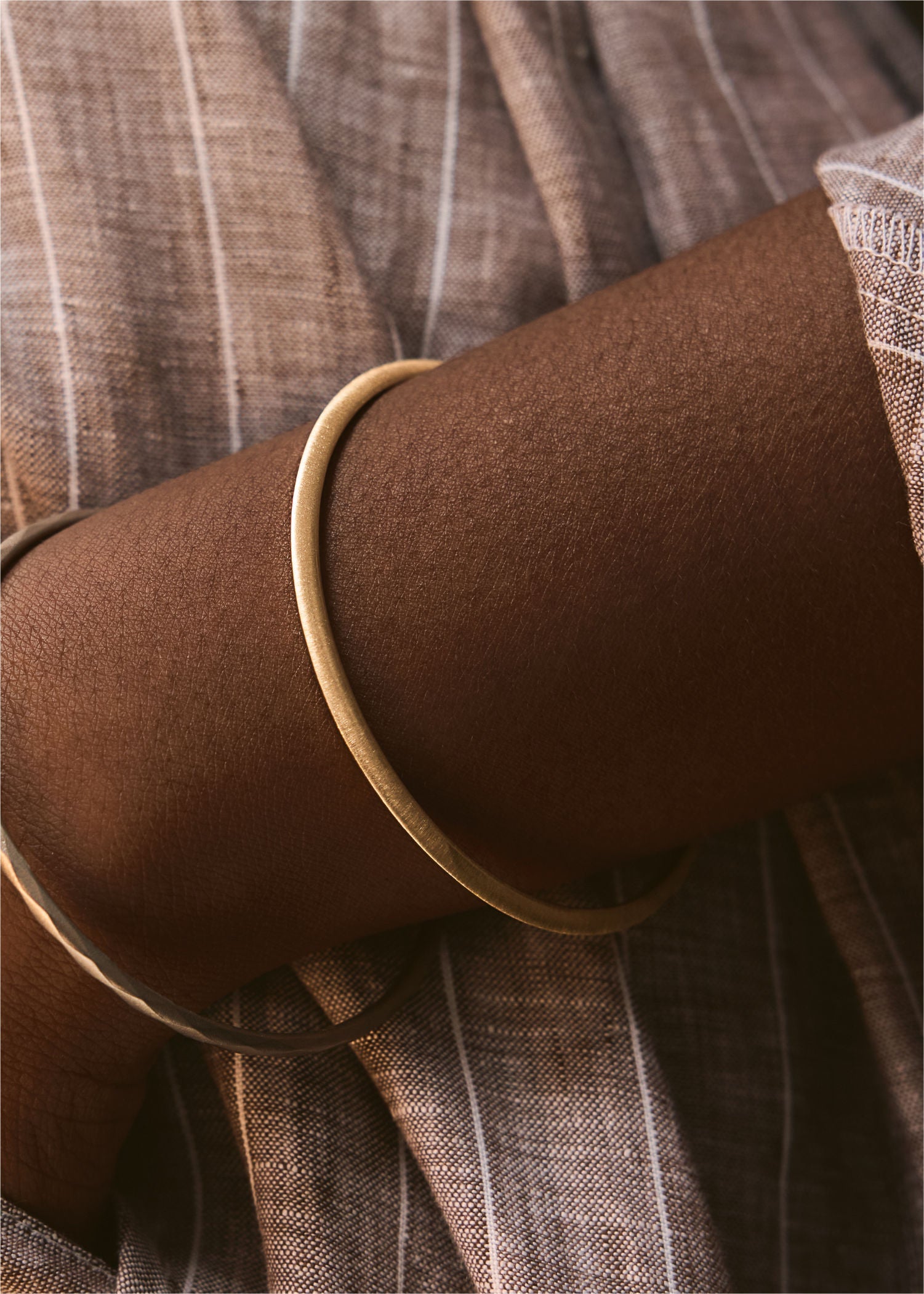 Yellow gold bracelet on a textured gray surface.