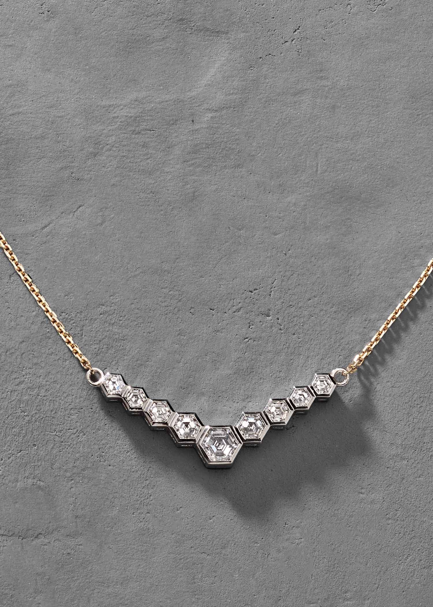 Gold hexagon diamond necklace shown on white background for product display.