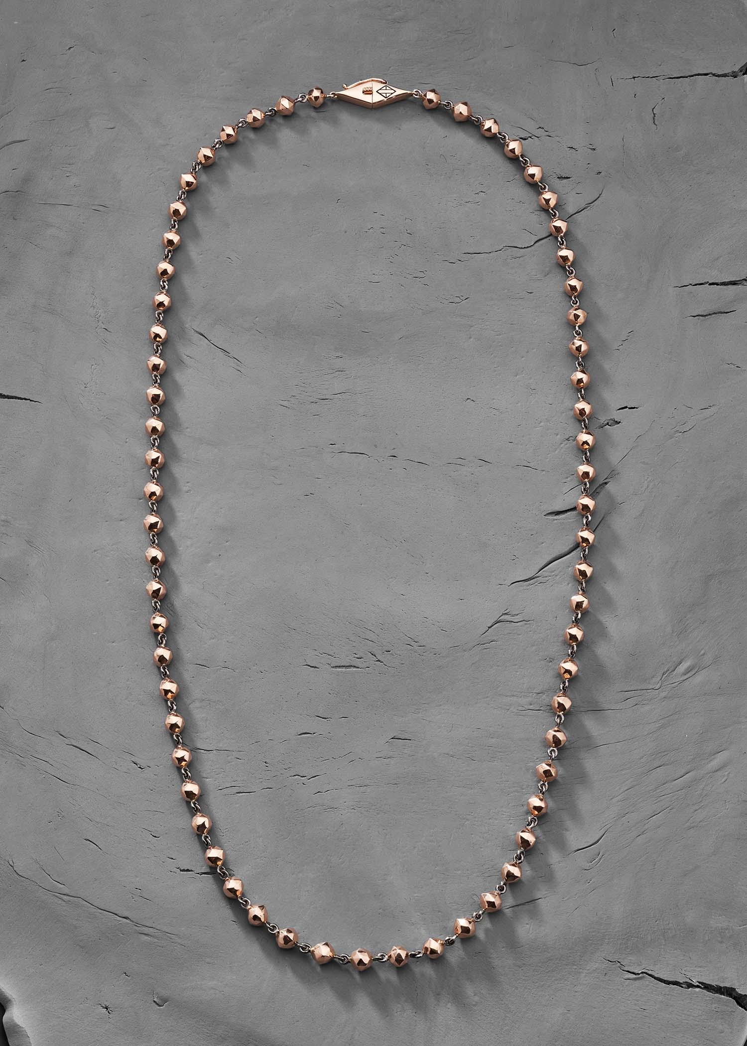 Model wearing facet bead necklace.