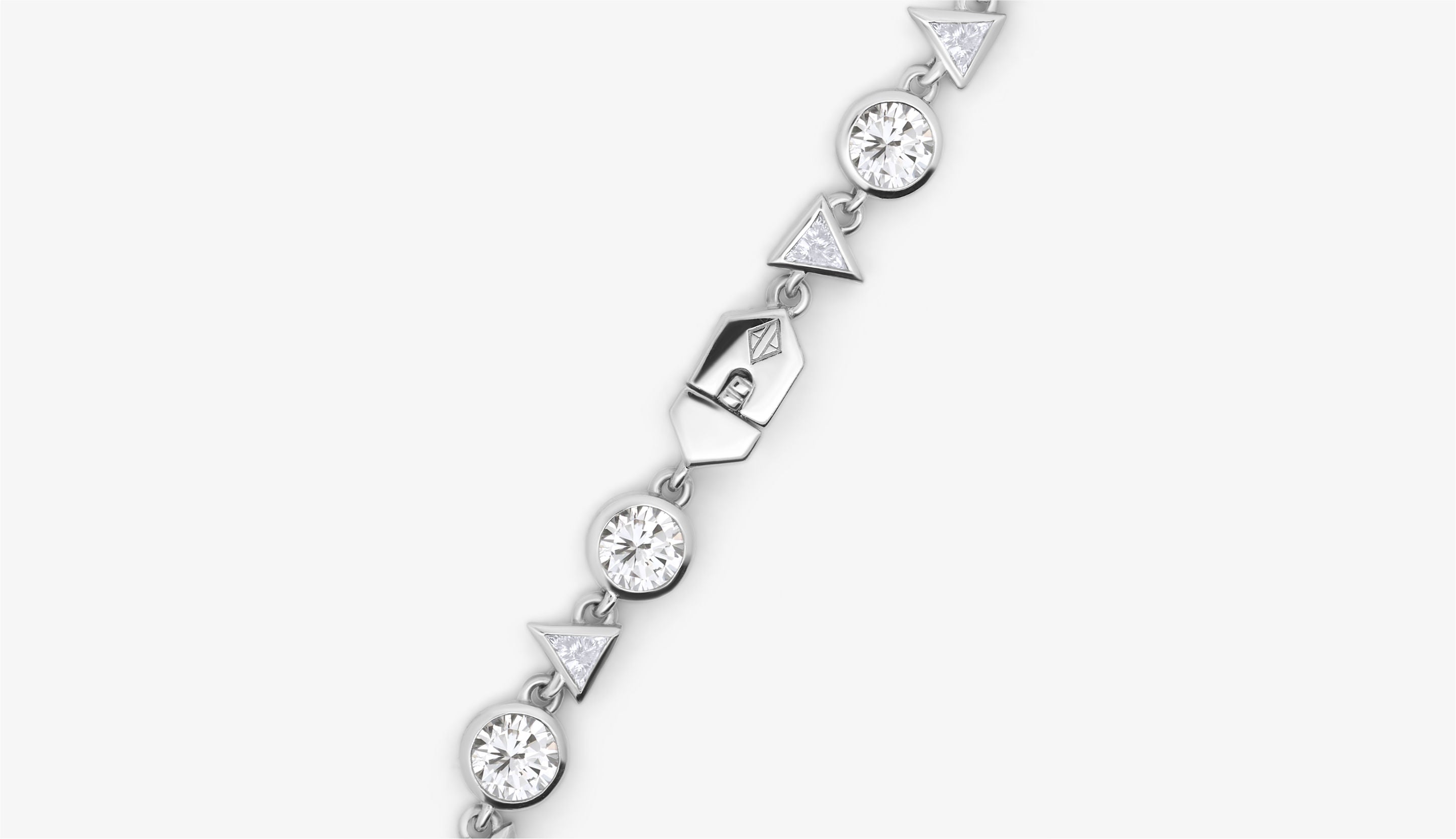 Blonde woman with slicked-back hair wearing a black strapless top and a choker necklace with a large light blue gemstone.