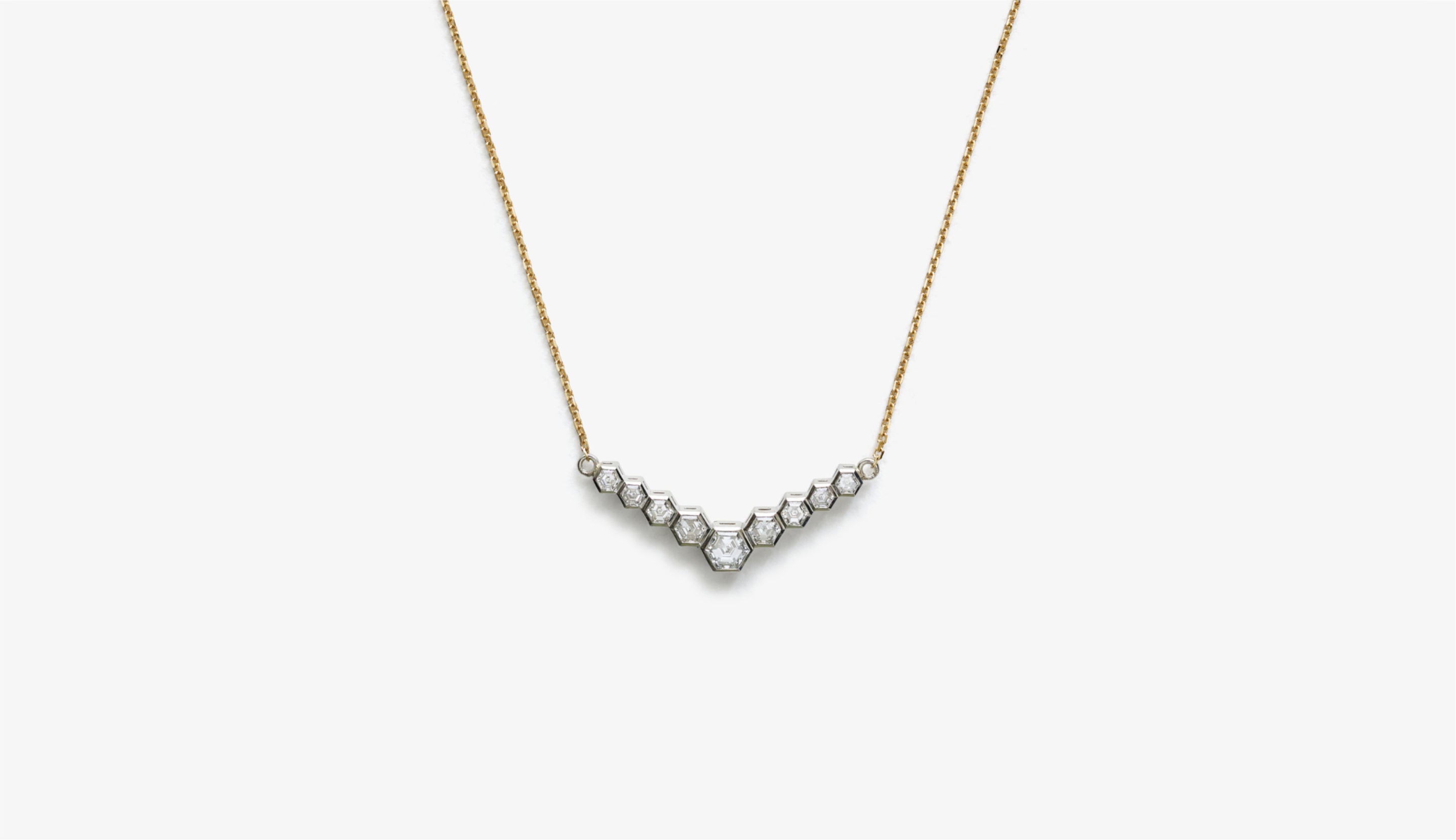 Blonde woman with slicked-back hair wearing a black strapless top and a choker necklace with a large light blue gemstone.