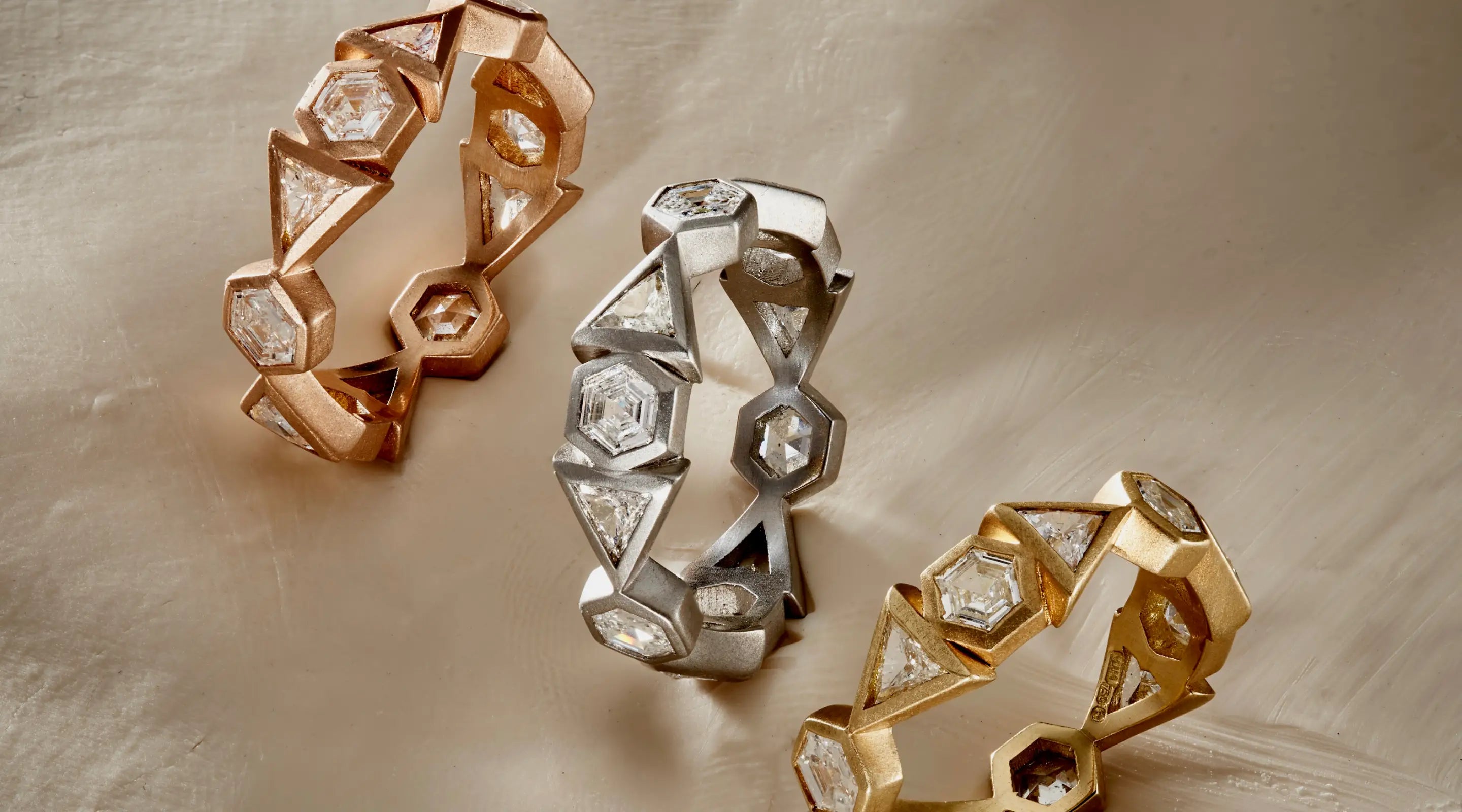 Blonde woman with slicked-back hair wearing a black strapless top and a choker necklace with a large light blue gemstone.