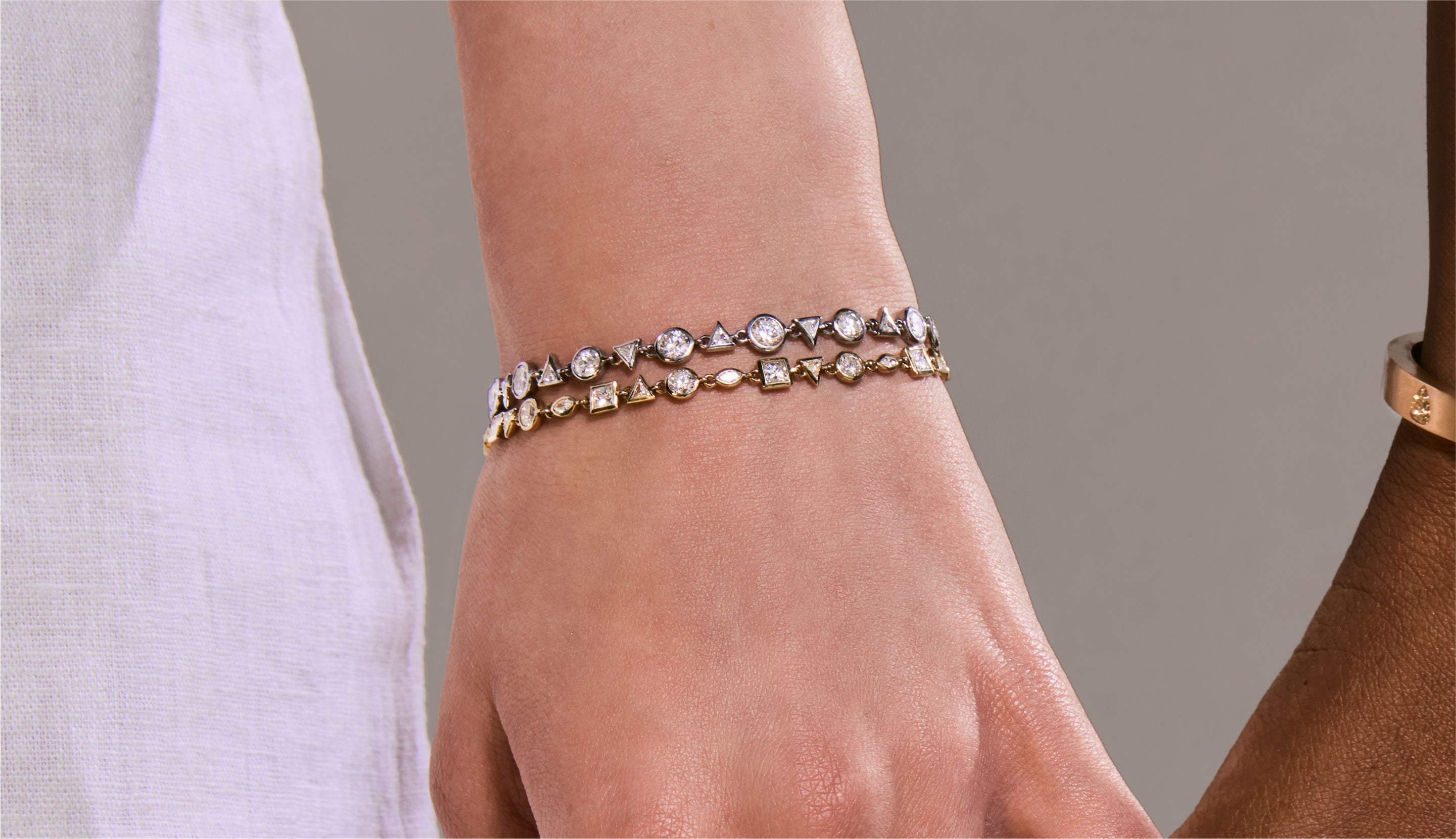 Blonde woman with slicked-back hair wearing a black strapless top and a choker necklace with a large light blue gemstone.