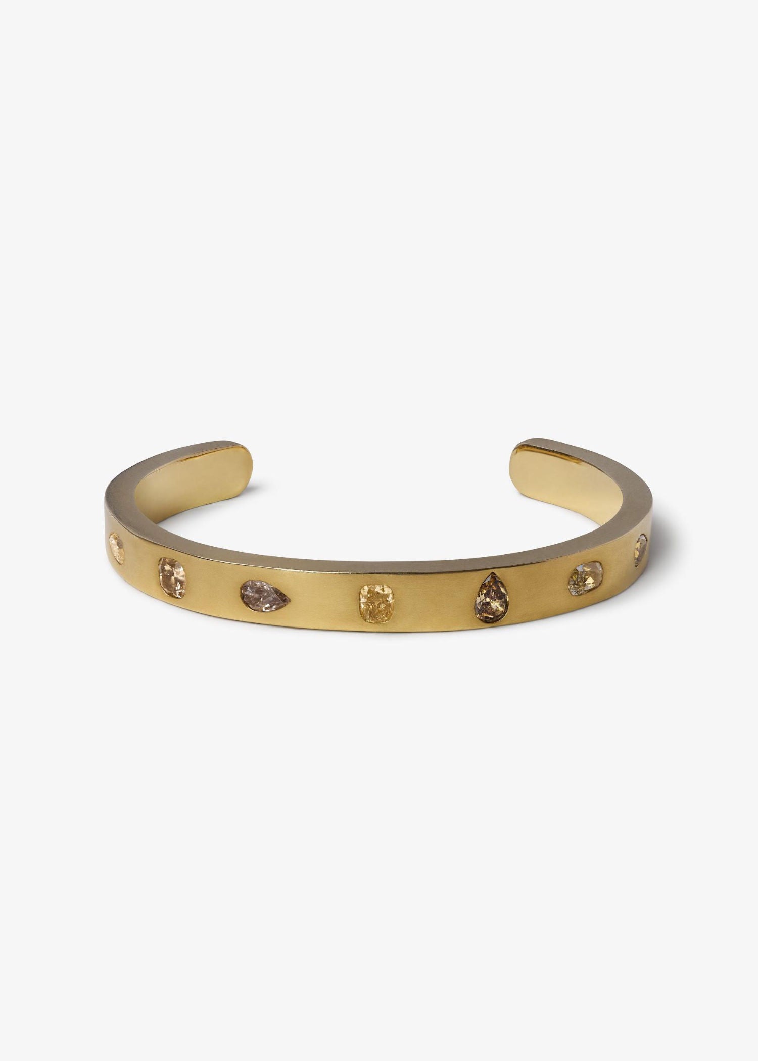 Gold bracelet on a textured gray surface.