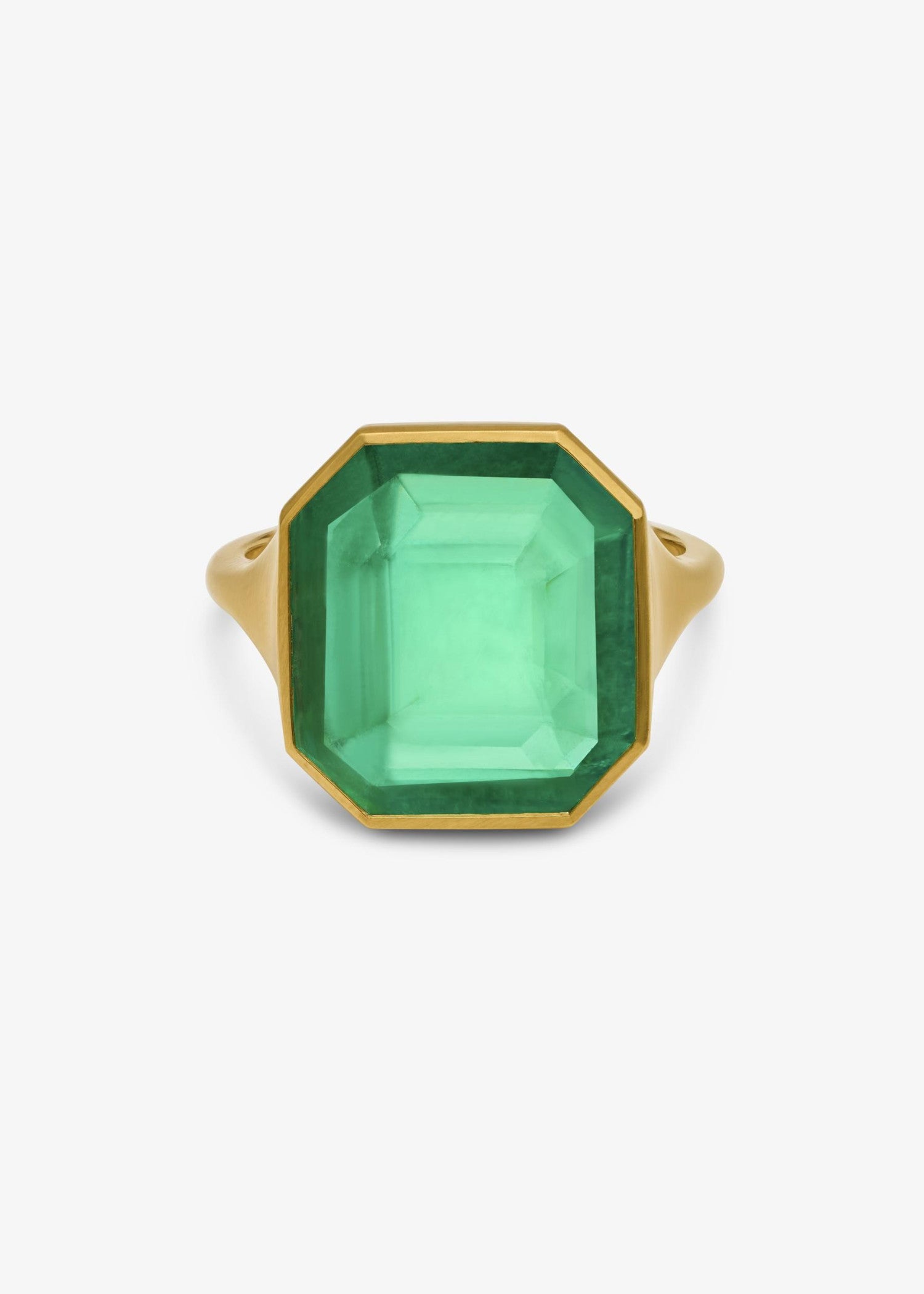 Woman wearing a green gemstone ring on her finger.