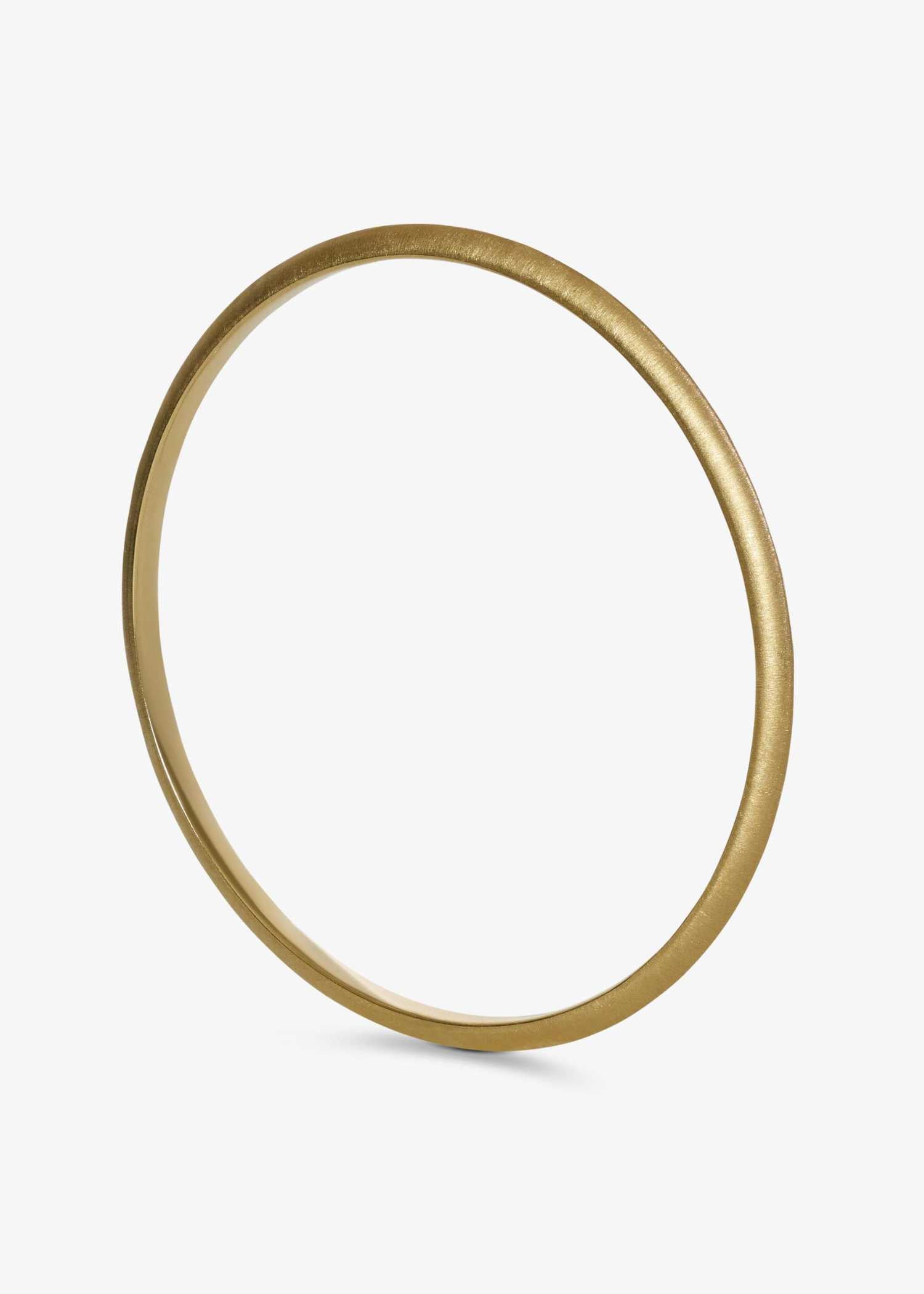 Yellow gold bracelet on a textured gray surface.